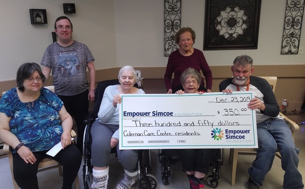 Coleman Residents Council holding up large donation cheque