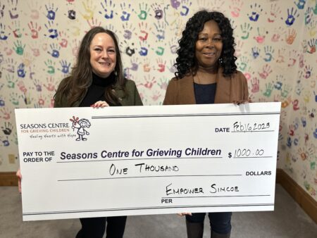 two people holding up donation cheque
