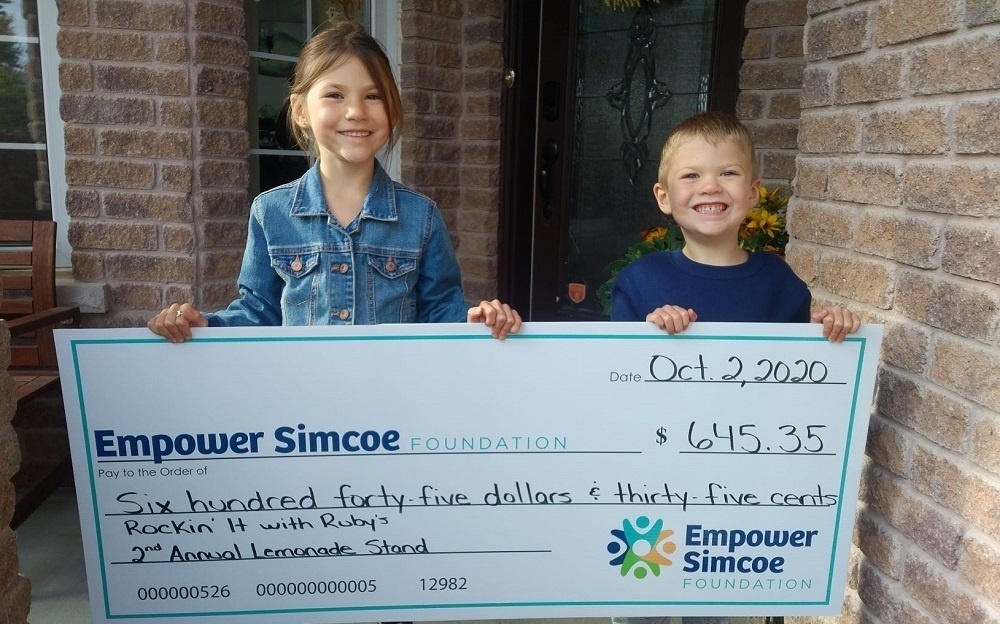 Kids holding up oversized cheque donation